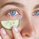 Beauty portrait of young woman moisturizing skin around eyes